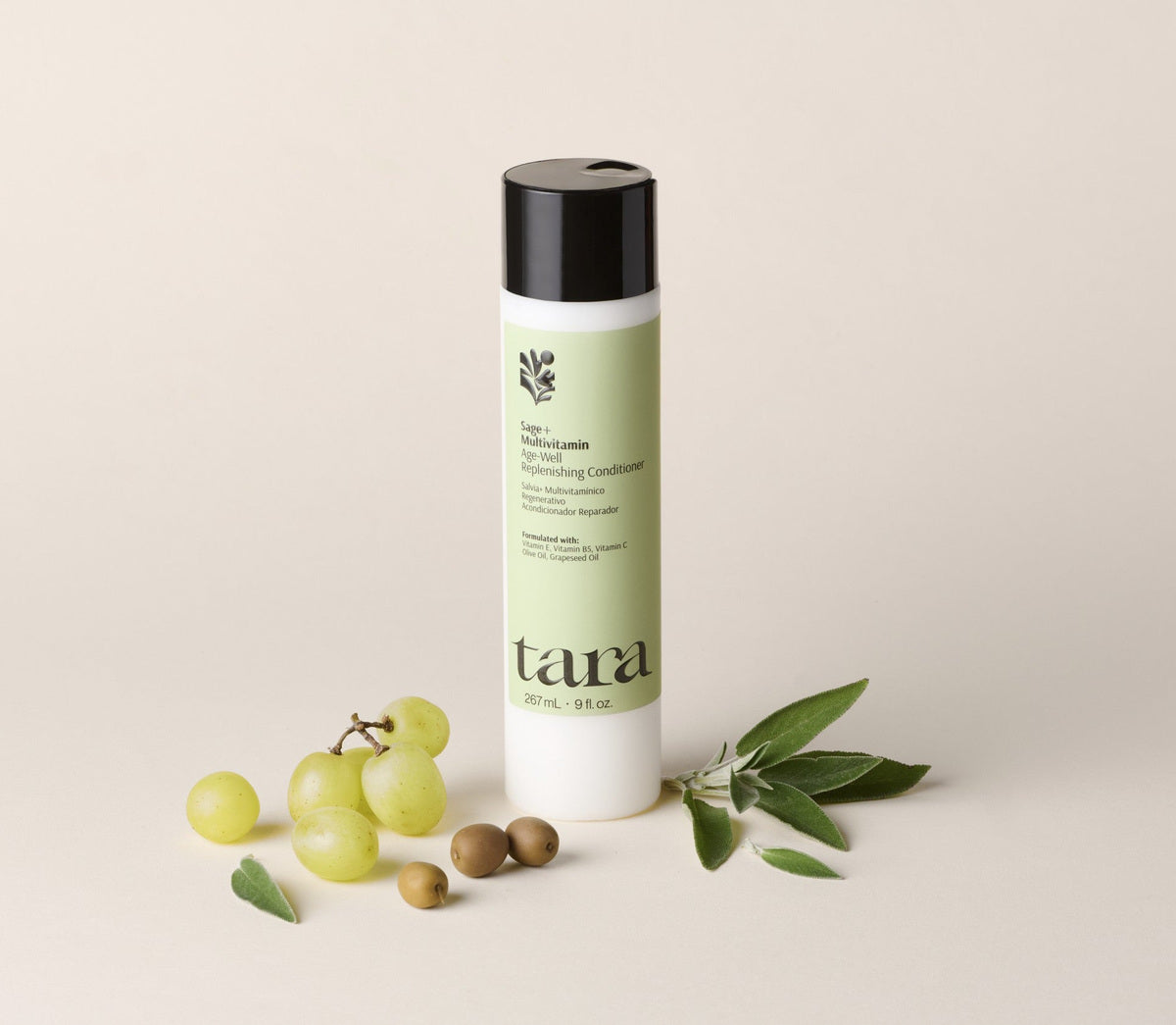 The conditioner bottle beside grapes, olives and sage leaves