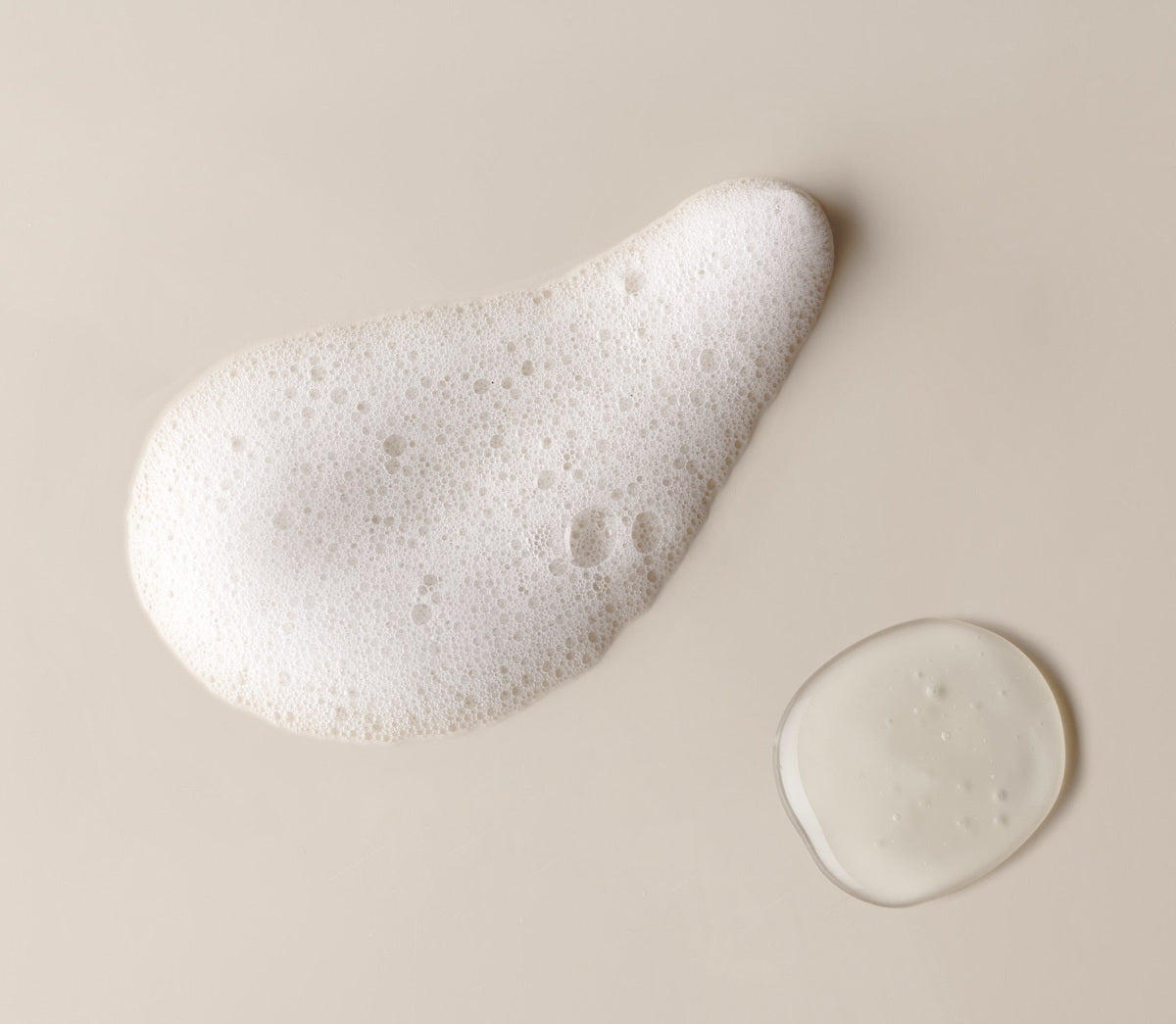 A swatch of dense white lather beside a drop of the unlathered gel