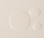 Three droplets of the serum on a flat surface, showing a water-light fluid